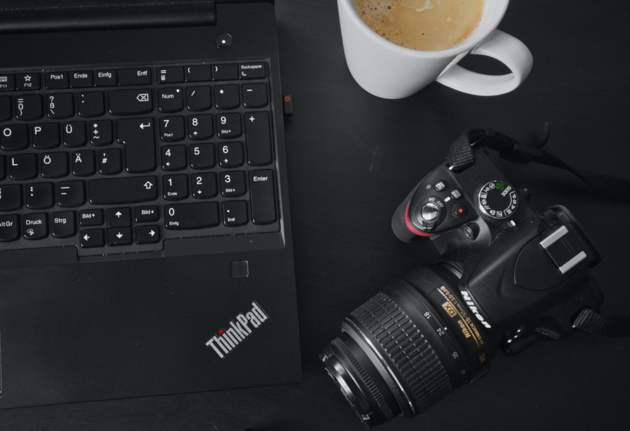 black thinkpad laptop and a dslr camera